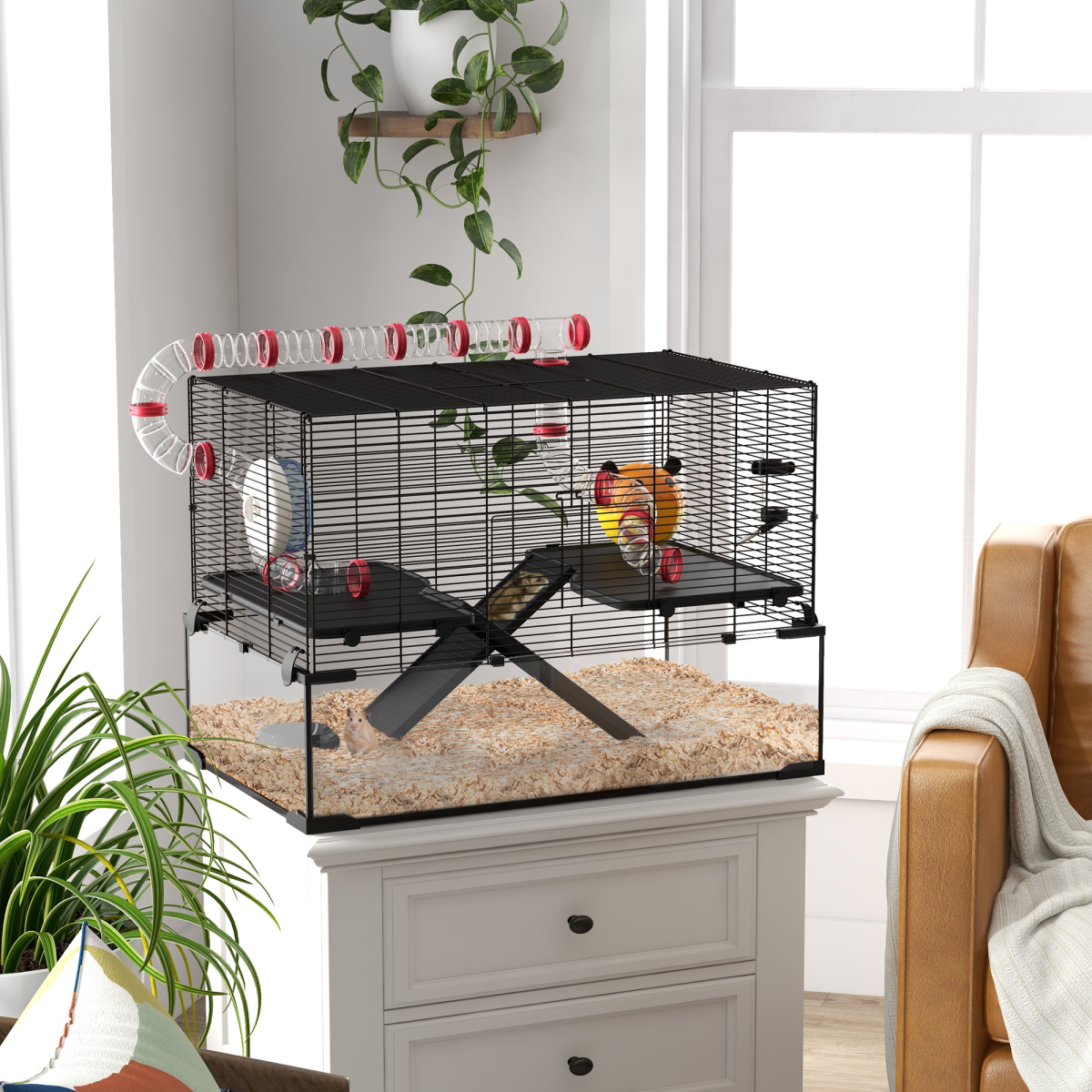 Pet cage on a small table with plants and a couch in the background